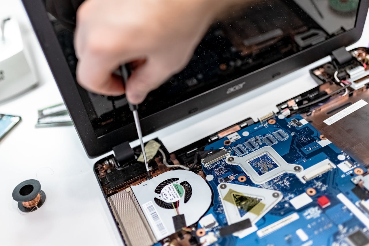 home-hero Technician repairing a laptop motherboard, focusing on electronic components.